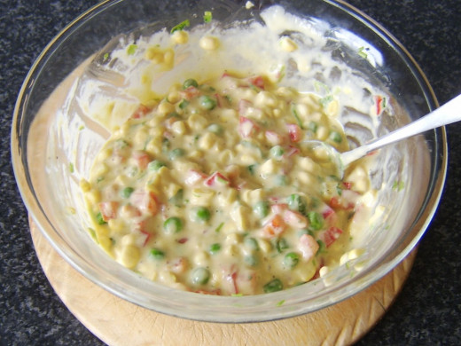 Batter and vegetables are stirred to combine