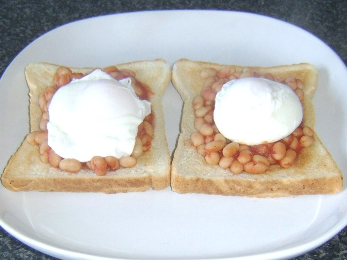 Poached eggs laid on spicy beans in tomato sauce on toast