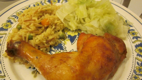 This chicken dinner plate is served with chicken fried rice mixed with vegetables paired with steamed cabbage.