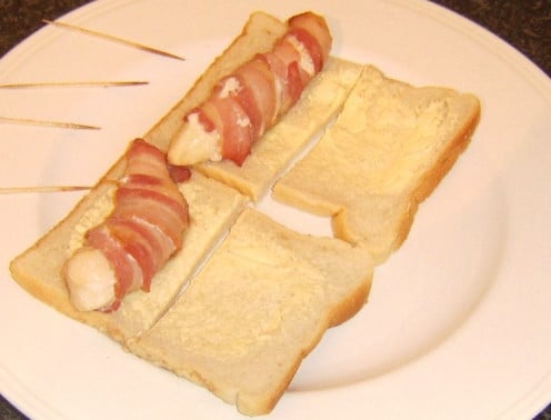 Chicken breast strips cooked in bacon are served on sandwiches