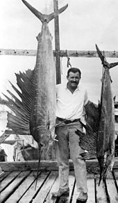 Ernest Hemingway posing with sailfish