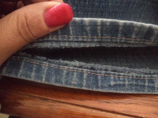Cut off the folded part of the pants as close as you can.