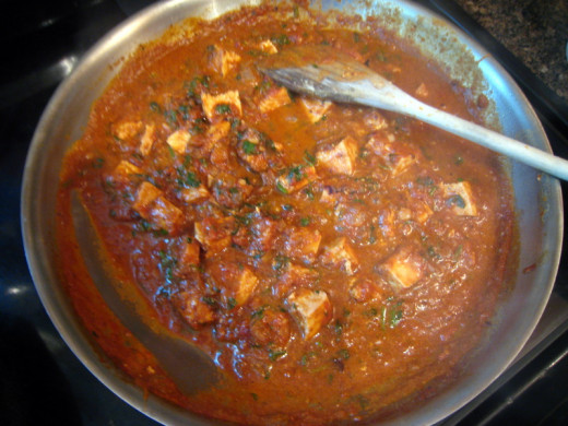 Cooking the masala after adding the tikka