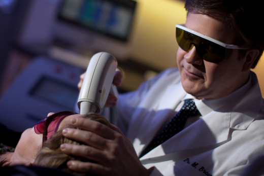 A dermatologist performing laser hair removal on a patient.