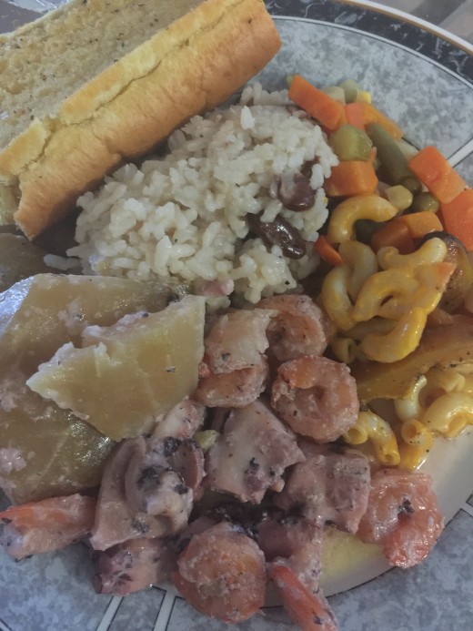 Garlic bread rice and red beans macaroni and cheese peas and carrot sauté octopus, shrimps and papayas
