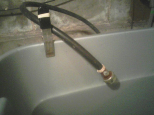 I use a heavy-duty clib and a thick rubber band to keep the fill hose in place. This rig means I don't have to hold the hose while the tub fills.