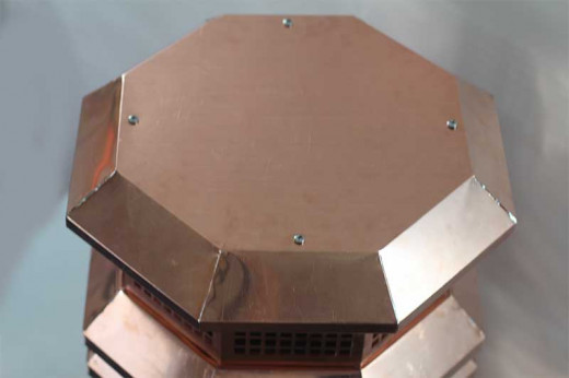 Octagonal cap, attached with stainless steel screws.