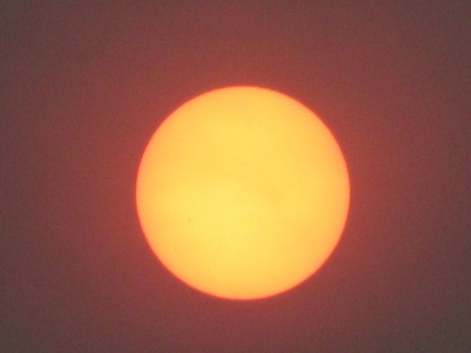 Here is a photo of the Sun rising the next morning around 7:15 a.m., twelve hours later. Shouldn't it be bright pinkish red as well?