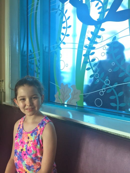 The birthday girl sitting in front of the Ariel window waiting to be seated. 