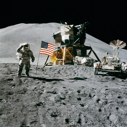 An astronaut of Apollo 15 standing on the surface of the moon with a USA Flag