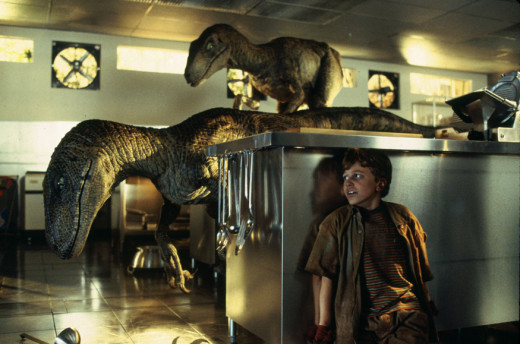 The kids in the raptors in the kitchen scene of Jurassic Park. In the book, it's just Timmy leading his sister in complete darkness armed only with a single pair of night vision goggles and some cold steaks as bait.