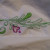 Close up of embroidered greenery on embroidered pillow case.