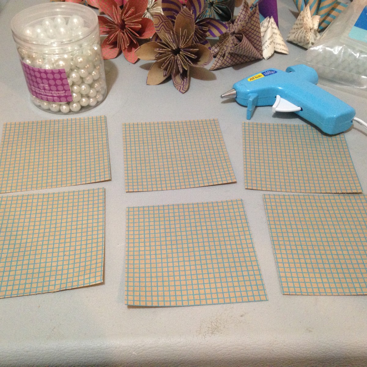 I'm using six squares for each flower. Normally I fold a whole bunch of flowers and after I have a bunch of them folded I glue them all at once. 