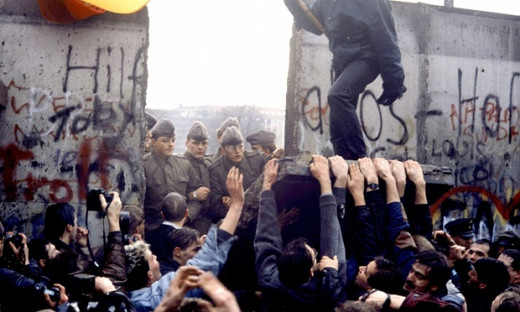 Berlin Wall falling, under the gaze of East German police.