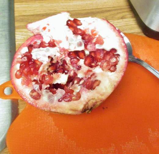 The pomegranate arils are shaped like corn kernels. The spoon method is a messy one for scraping these out.