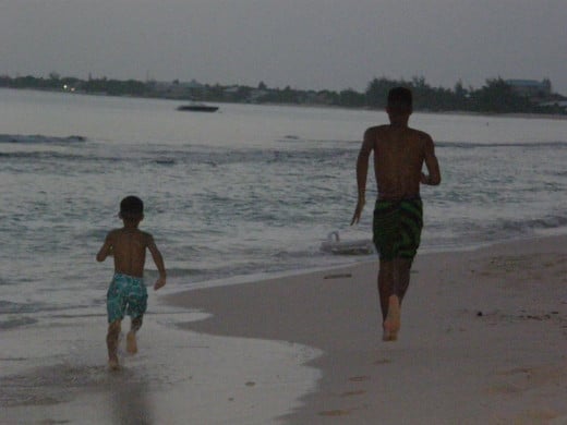 Nicholas and Quincy running along Seven Mile Beach