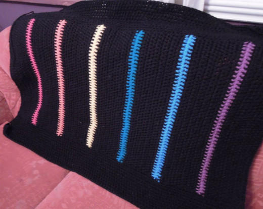 Finished chunky rainbow crochet blanket.