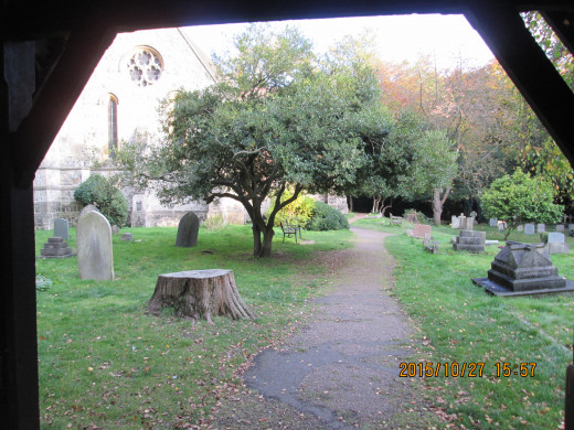 A look through the lychgate of a village church at the memorials. What nationality are you when you're dead? This is Holy Innocents, High Beech near Epping, Essex - at one time within the Danelaw,