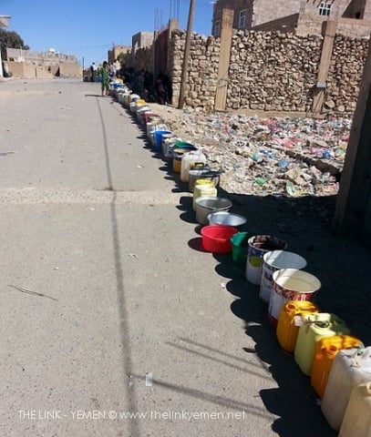 A Long Queue of Empty Water Cans and Bowls