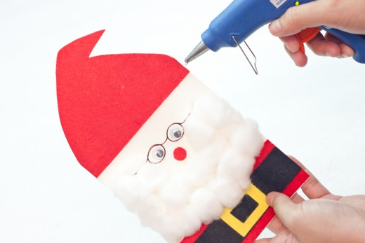 Step 17.   Hot glue the red cap on the topmost part of Santa’s face.  Make sure to leave a small space in between the face and the cap.  This will provide a little space for Santa’s hair.  
