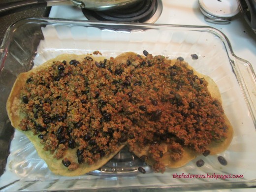 Then, spread half the meat mixture (ground turkey, taco seasoning, Italian dressing, black beans, salsa)