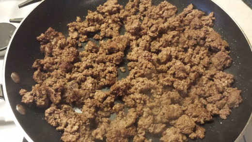 Brown the ground beef and add peppers and onions if you are choosing to do so