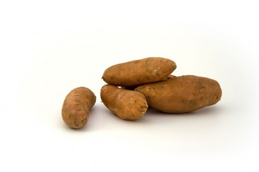 This image shows several sweet potatoes. When cut open, sweet potatoes are a light orange color inside.