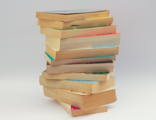 Photo of yellowed paperbacks stacked on top of each other.