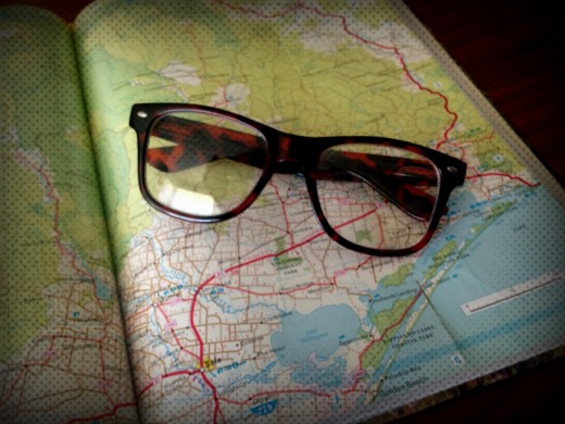 Image of a pair of reading glasses sitting on top of a road map.