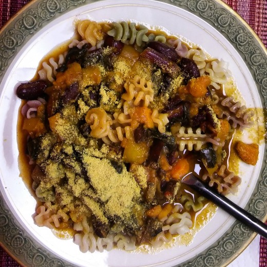 Sweet potato and beet green stew served over tricolor vegan pasta!