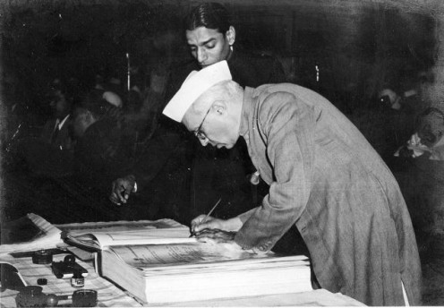 First prime minister, Jawaharlal Nehru signing in the constitution of India.