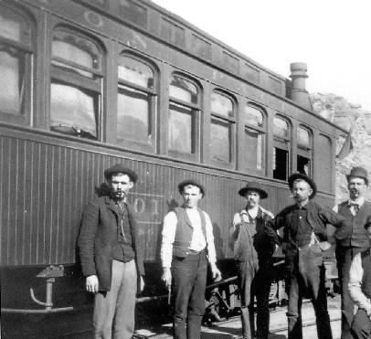 Men by a passenger train in the 1800s