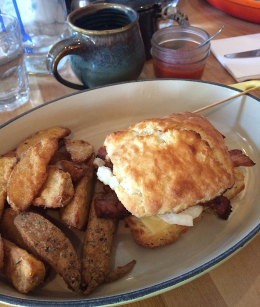 Mallard Cottage's Breakfast Sandwich with house-made bacon and wedges on the side.
