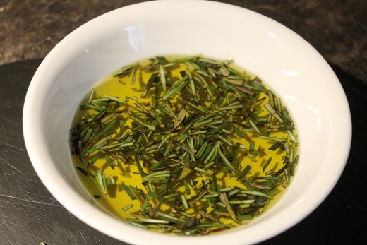 The leaves of two sprigs fresh rosemary, finely chopped, infusing the olive oil and softening up.