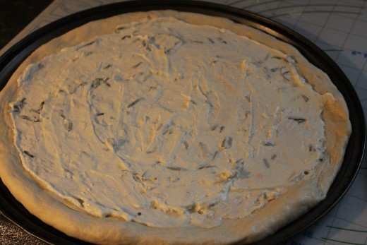 Pizza BIanche Step One: Schmear white sauce all over the dough, leaving about 1/2 inch border for the crust.