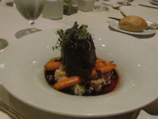 An elegant dish of short ribs surrounded by delicious veggies.