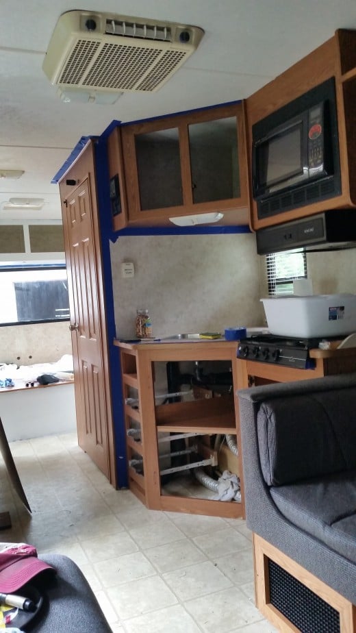 Kitchen with a semi view of the back bedroom with the primer on it. 
