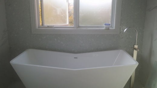 A gorgeous tub is easy to afford when you've painted on a marble look on the walls, rather than purchasing marble tile.