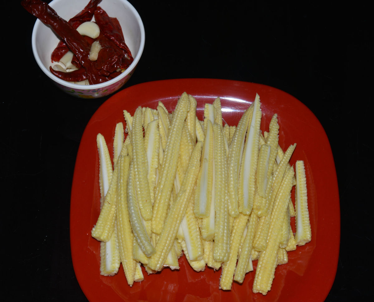 Step one: Wash the baby corn and slit each of them lengthwise. Make a paste of soaked red chilies, ginger, and garlic. 