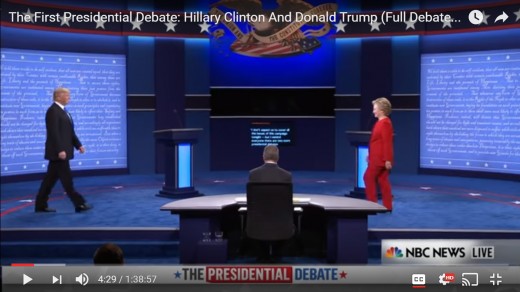 Both candidates are seen in frame; HRC's head is still downward, and DJT's head remains upright.  HRC is in front of her podium. DJT has not yet reached his podium.