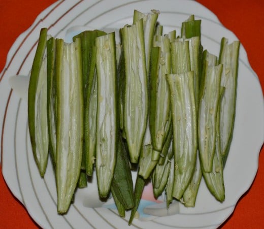 Step one: Wash and pat dry okra. Slit them lengthwise.