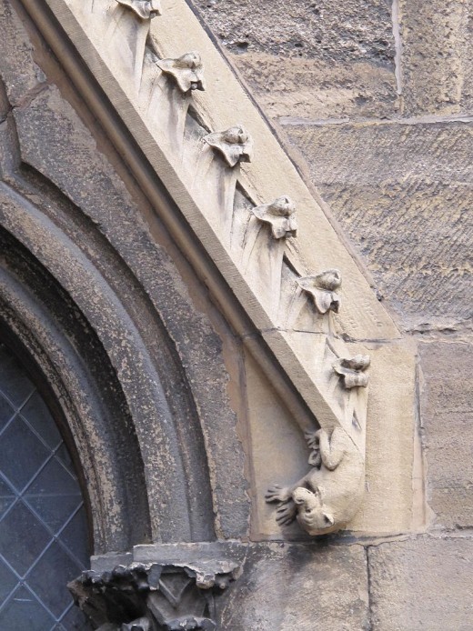 Relief of the fall of a devil on a lateral entrance on the facade of the Saint-Martin cathedral in Colmar, France.