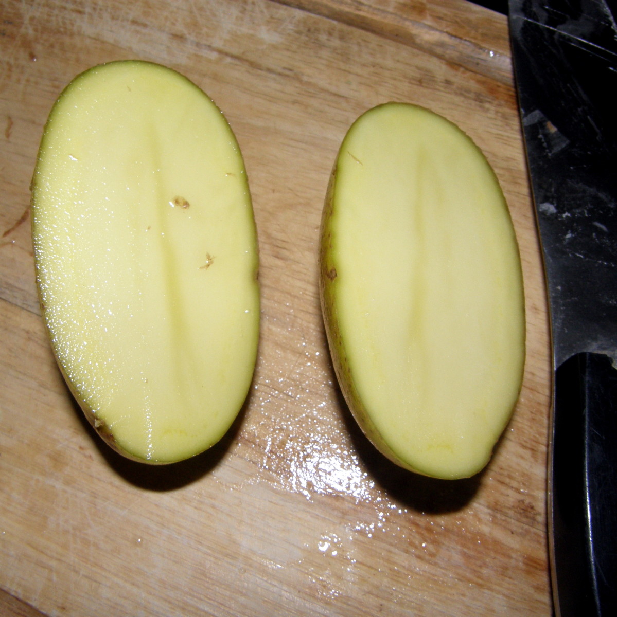 Start by slicing the potatoes in half.  Then slice each half down the middle and then cut into chunks.
