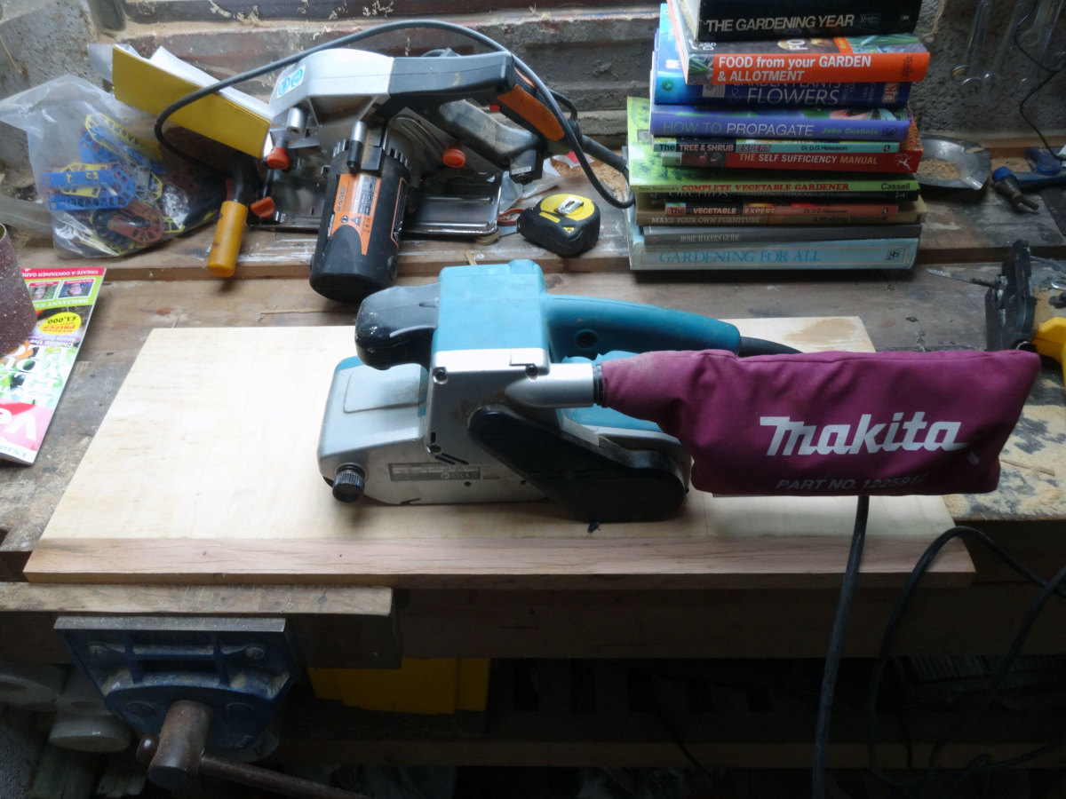 Taking the surface back to the bare wood with a belt sander.
