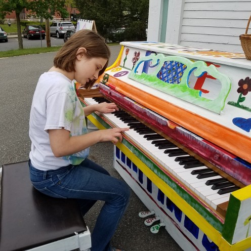 Author's daughter playing an original composition on the piano in front of our UU church. 