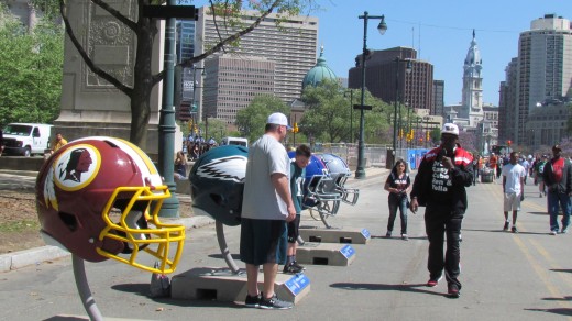 Visitors took photographs in the midst of the large helmet for individual teams. Young and old found this display outside of the entrance to NFL Draft.