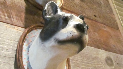 A photo of one of the adorable statues of a dog that is featured on the wall of the cafÃ©.