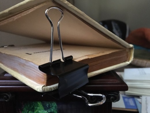 The arm of the binder clip can help keep other pages from sticking to your glue.