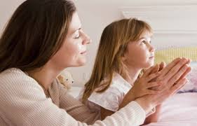 A mother teaching her child to pray