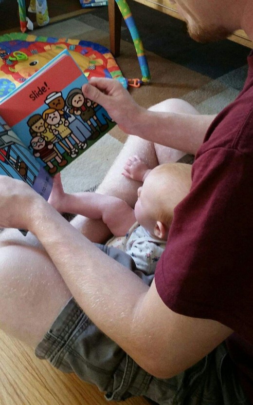 Reading on Dad's lap.